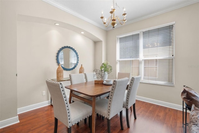 dining area featuring an inviting chandelier, ornamental molding, and dark hardwood / wood-style floors