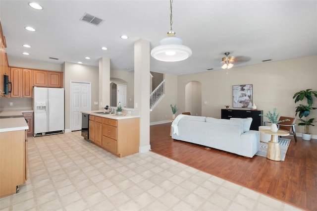 kitchen with sink, decorative light fixtures, light wood-type flooring, ceiling fan, and black appliances