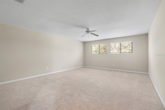 unfurnished room featuring ceiling fan, light carpet, and a textured ceiling