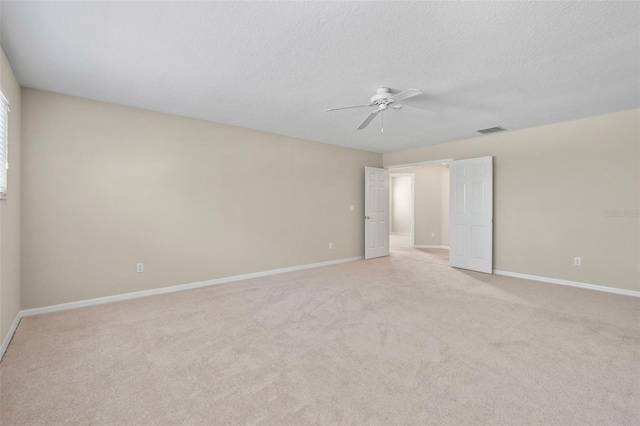 unfurnished room with ceiling fan, light colored carpet, and a textured ceiling