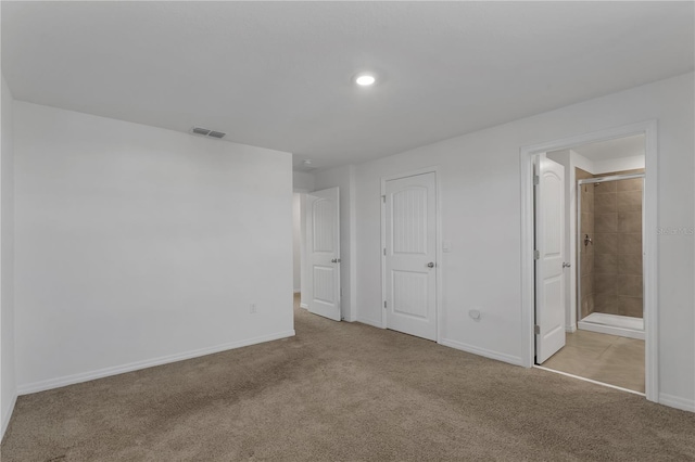 unfurnished bedroom with light colored carpet and ensuite bathroom