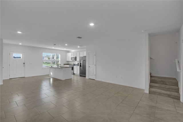 unfurnished living room featuring sink and light tile patterned floors