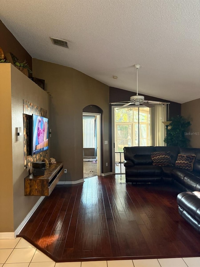 living room with lofted ceiling, hardwood / wood-style floors, and a textured ceiling