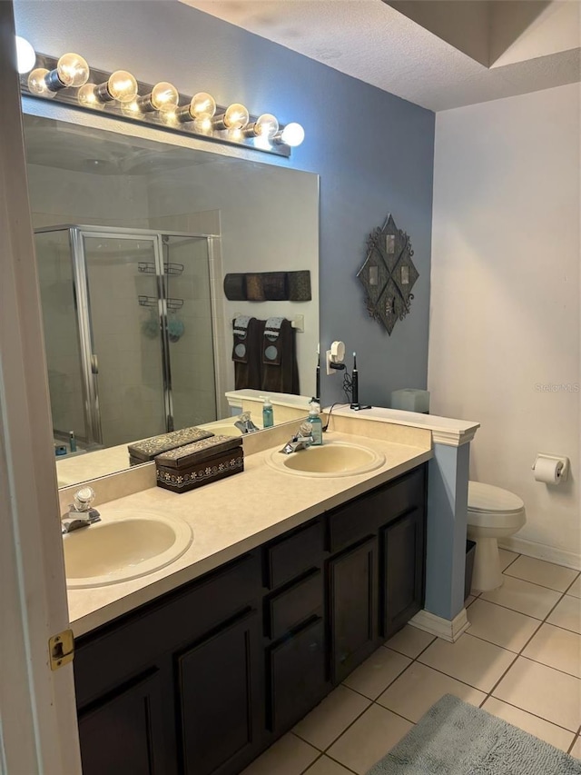 bathroom featuring vanity, toilet, an enclosed shower, and tile patterned flooring