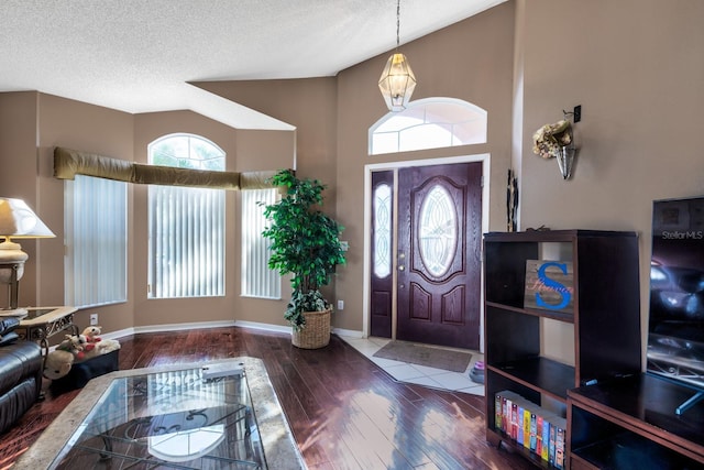 foyer featuring a textured ceiling, lofted ceiling, and wood-type flooring