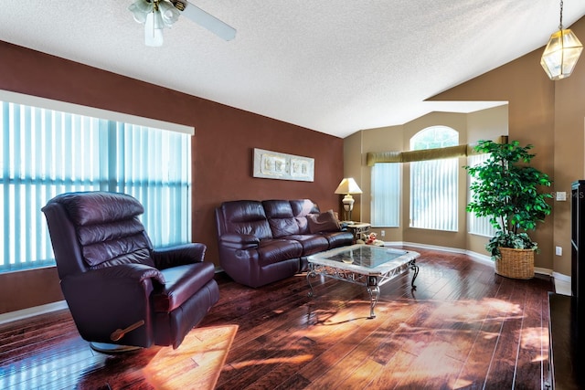 living room featuring ceiling fan, vaulted ceiling, dark hardwood / wood-style flooring, and a textured ceiling