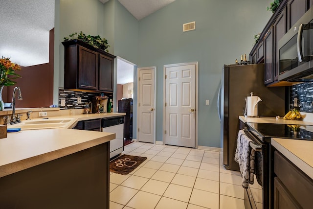 kitchen with dishwashing machine, light tile patterned floors, sink, electric range, and dark brown cabinets