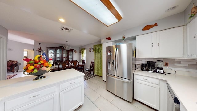 kitchen with tasteful backsplash, light tile patterned floors, white cabinets, and stainless steel fridge with ice dispenser