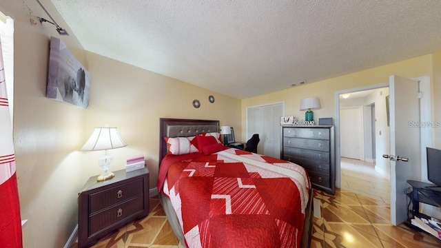 bedroom with light tile patterned floors, visible vents, and a textured ceiling