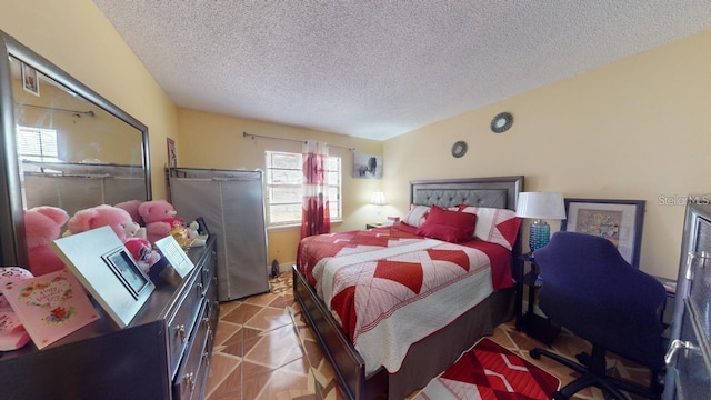 bedroom featuring a textured ceiling and light tile patterned floors