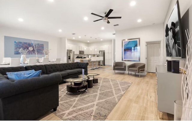 living room featuring light hardwood / wood-style floors and ceiling fan