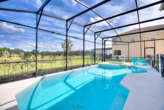 view of pool with a patio area, an in ground hot tub, and glass enclosure