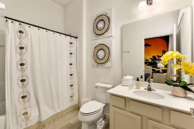 full bathroom with vanity, shower / tub combo, and toilet