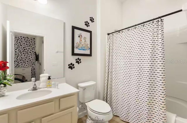 full bathroom featuring shower / tub combo with curtain, vanity, and toilet