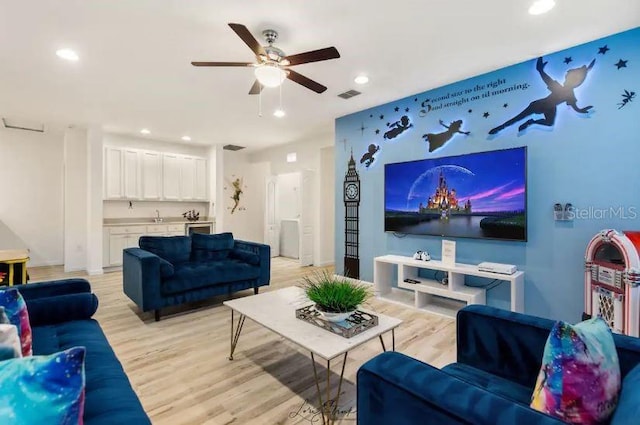 living room with sink, light hardwood / wood-style floors, and ceiling fan