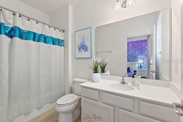 full bathroom featuring vanity, shower / bath combination with curtain, and toilet