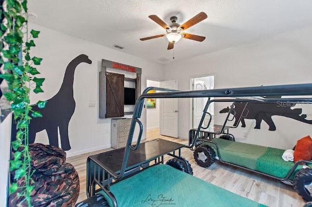 exercise area with hardwood / wood-style floors and ceiling fan