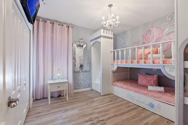 bedroom with wood-type flooring and a notable chandelier