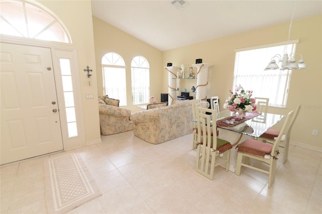 tiled dining space with an inviting chandelier, high vaulted ceiling, and a wealth of natural light