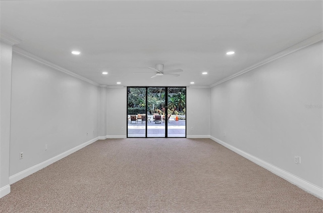 spare room with crown molding, light colored carpet, ceiling fan, and a wall of windows