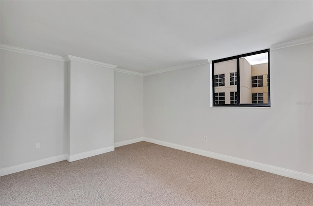 empty room featuring ornamental molding and carpet