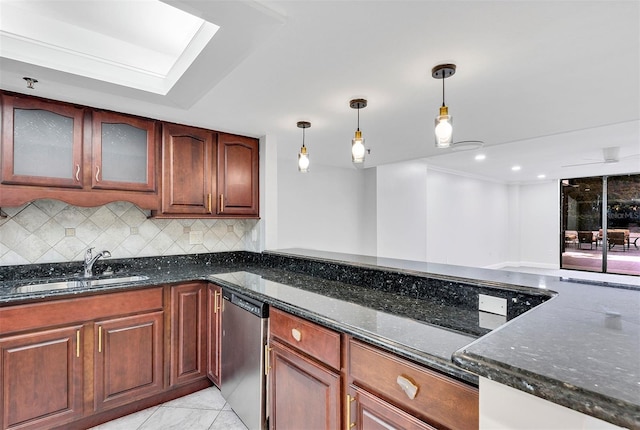 kitchen with sink, hanging light fixtures, dark stone countertops, stainless steel dishwasher, and backsplash