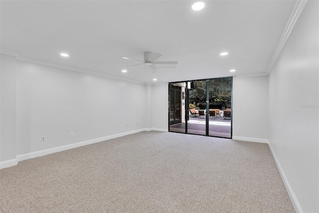 unfurnished room featuring expansive windows, ceiling fan, ornamental molding, and carpet floors