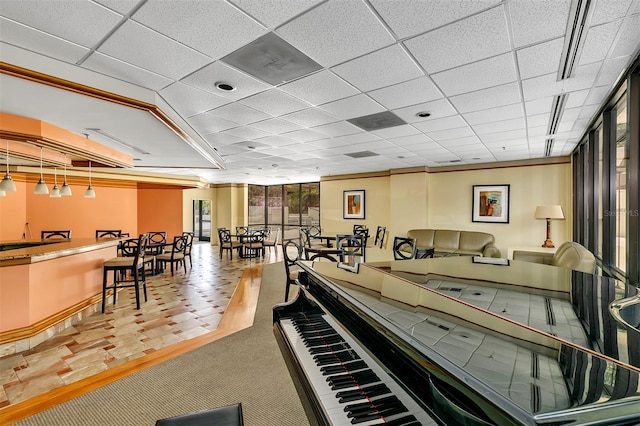 misc room featuring carpet floors and a paneled ceiling