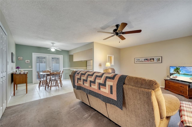 carpeted living room with french doors, ceiling fan, and a textured ceiling