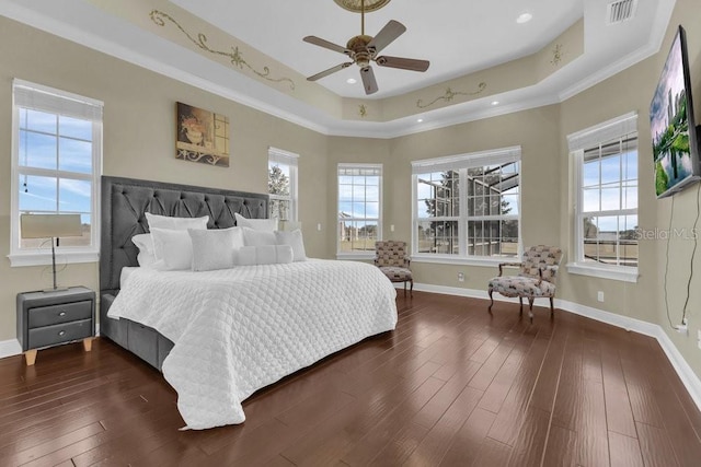 bedroom featuring dark wood-type flooring, crown molding, and a raised ceiling