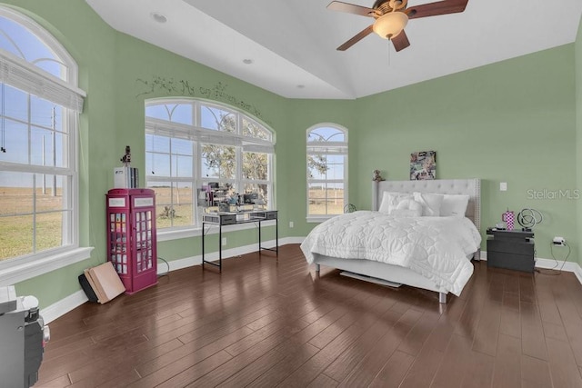 bedroom with ceiling fan, dark hardwood / wood-style floors, vaulted ceiling, and multiple windows