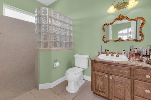 bathroom featuring vanity, toilet, tile patterned flooring, and a tile shower