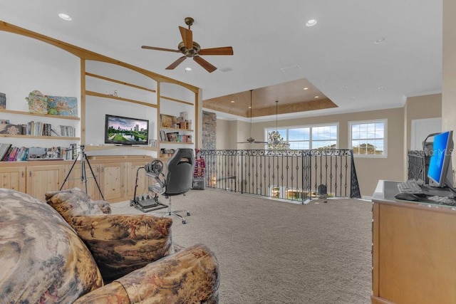 carpeted office space featuring crown molding, a raised ceiling, and ceiling fan