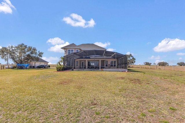 rear view of property featuring a yard and a lanai