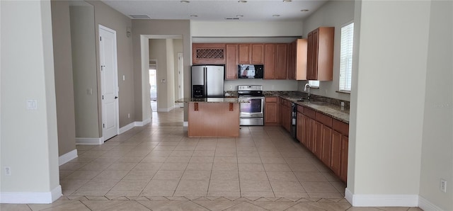 kitchen with light tile patterned flooring, a kitchen island, sink, dark stone counters, and black appliances