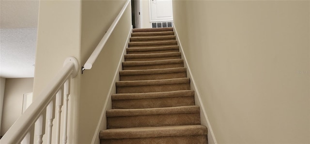 staircase with a textured ceiling