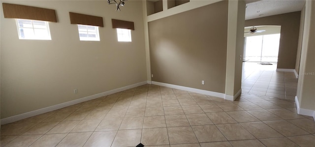 tiled empty room featuring ceiling fan