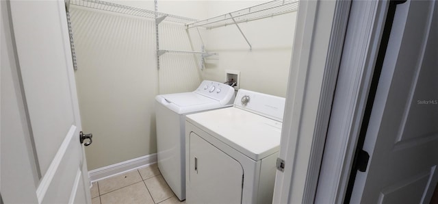 laundry room featuring washing machine and dryer and light tile patterned floors