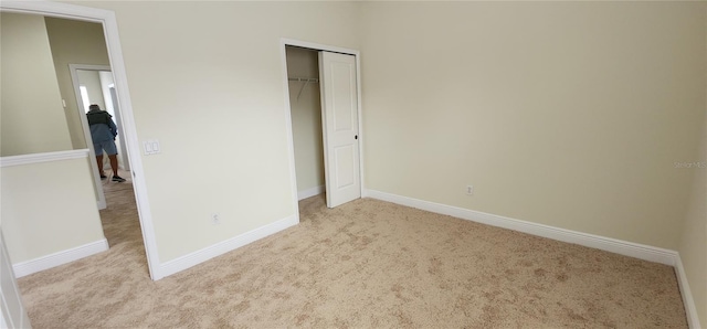 unfurnished bedroom featuring a closet and light carpet