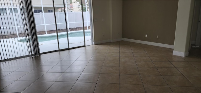 empty room featuring a healthy amount of sunlight and dark tile patterned flooring