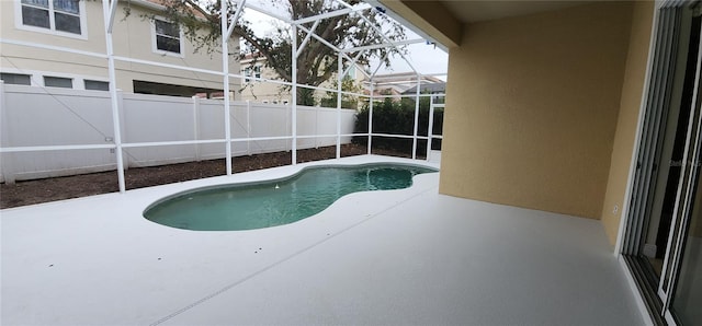 view of swimming pool featuring glass enclosure and a patio area