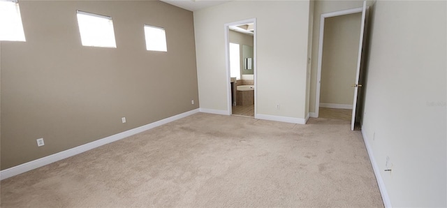 unfurnished bedroom with light carpet and ensuite bath