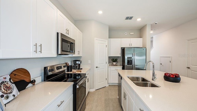 kitchen featuring appliances with stainless steel finishes, sink, and white cabinets