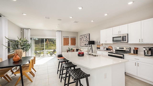 kitchen featuring stainless steel appliances, sink, a center island with sink, and white cabinets