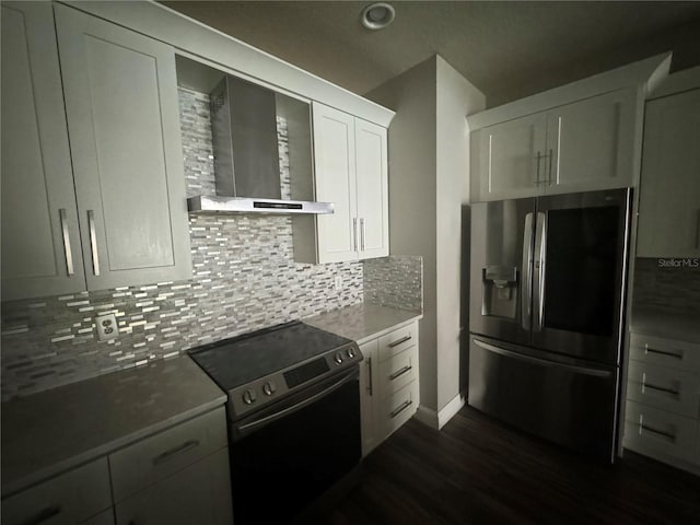 kitchen with wall chimney range hood, dark wood-type flooring, stainless steel appliances, tasteful backsplash, and white cabinets