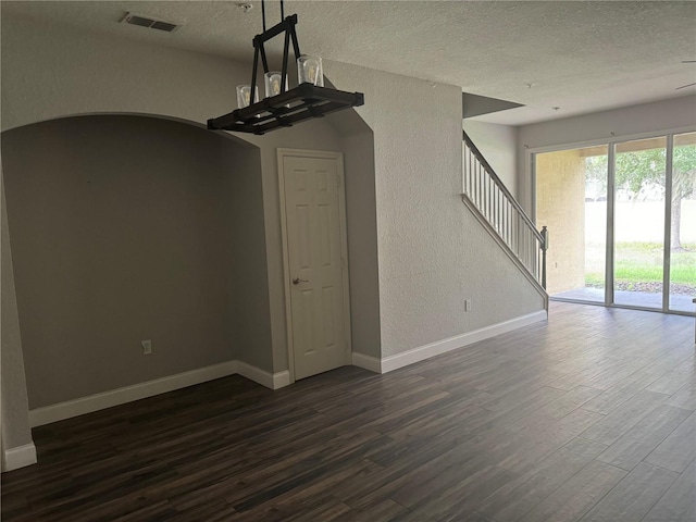 unfurnished living room with dark hardwood / wood-style floors and a textured ceiling