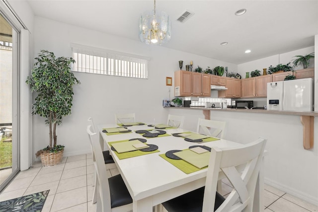 tiled dining area featuring a chandelier