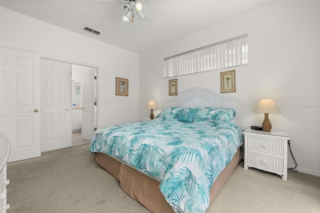 carpeted bedroom featuring ensuite bath and ceiling fan