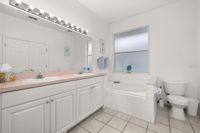 bathroom featuring vanity, toilet, tile patterned flooring, and tiled tub