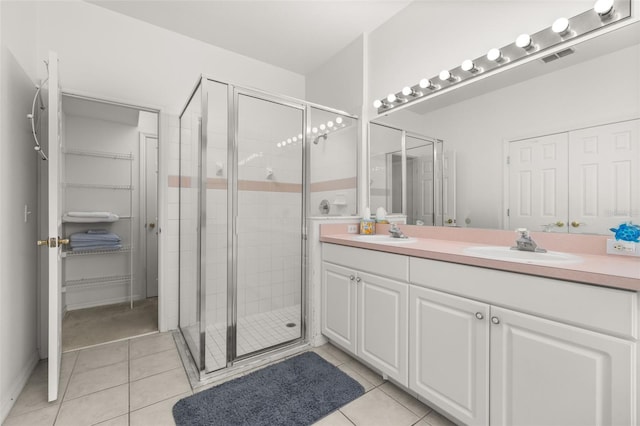 bathroom with tile patterned flooring, vanity, and a shower with door